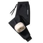 OUTDOORS NORDIC black fleece-lined sweatpants with an elastic drawstring waist and zippered pocket detail.