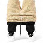 OUTDOORS NORDIC Fleece 24/7 Pants featuring a thick beige sherpa fleece lining and black elasticated cuffs.
