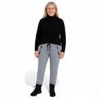 Woman wearing OUTDOORS NORDIC grey fleece 24/7 pants with an elastic drawstring waist and black zippered pockets.