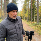 Man walking his black labrador on a forest path wearing the navy blue Cozy Waffle Beanie