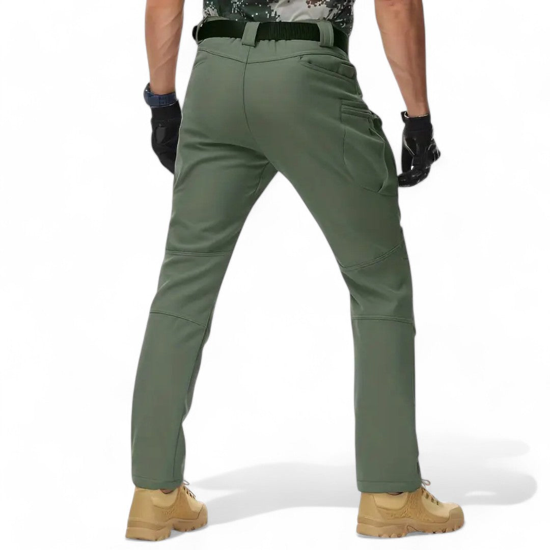 OUTDOORS NORDIC olive green utility fleece pants with multiple pockets, worn by a man in a back view.