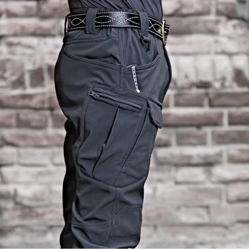 OUTDOORS NORDIC utility fleece pants in dark grey with multiple cargo pockets and a durable, windproof stretch fabric.