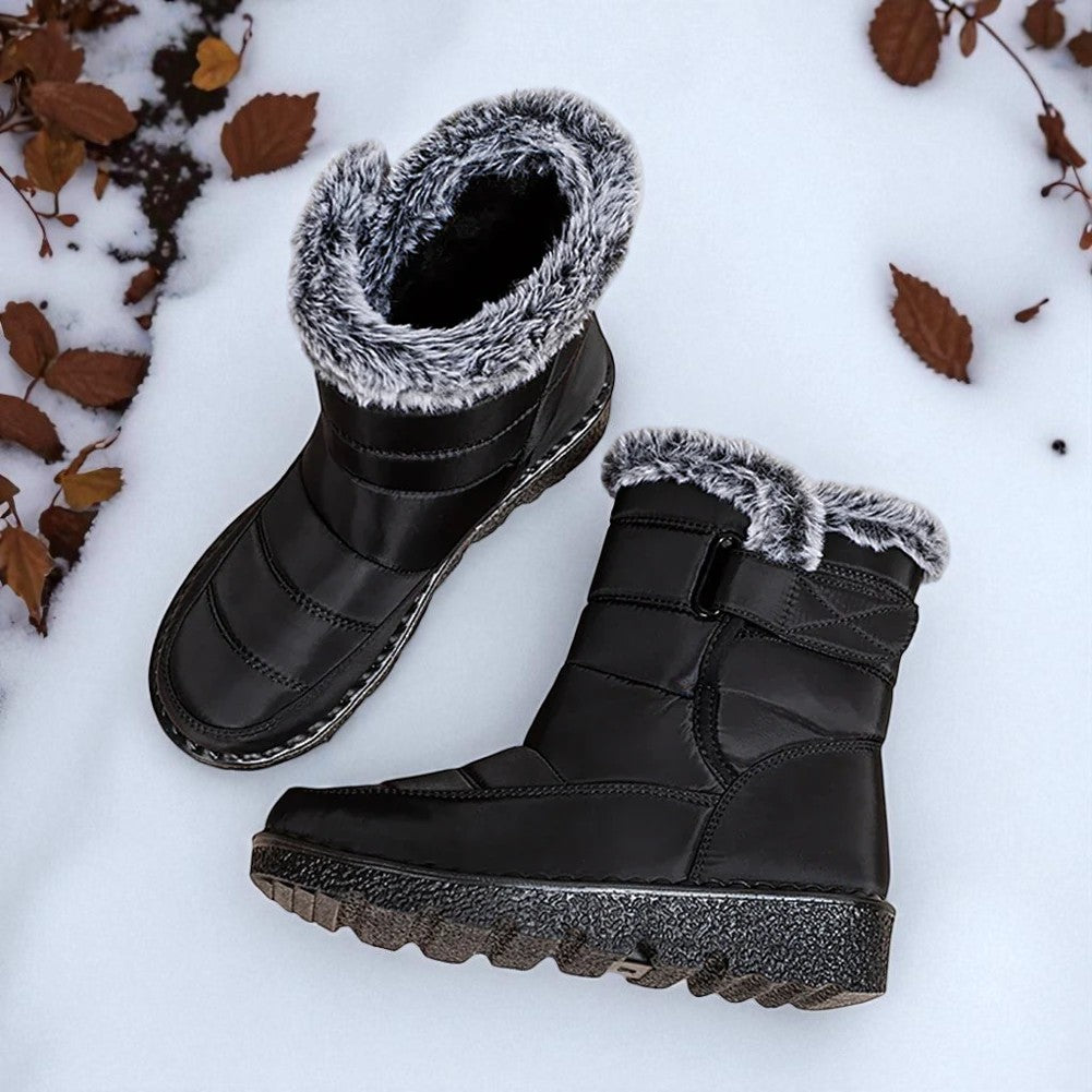 OUTDOORS NORDIC black waterproof winter boots with faux fur lining and velcro strap, set on snowy ground.