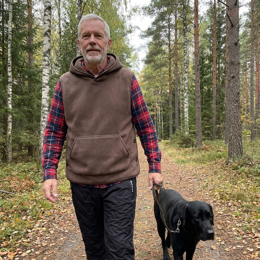 Man runt 60 på hundpromenad i skogen i brun Sherpa Hoodie Vest och svarta Warm Fleece Pants